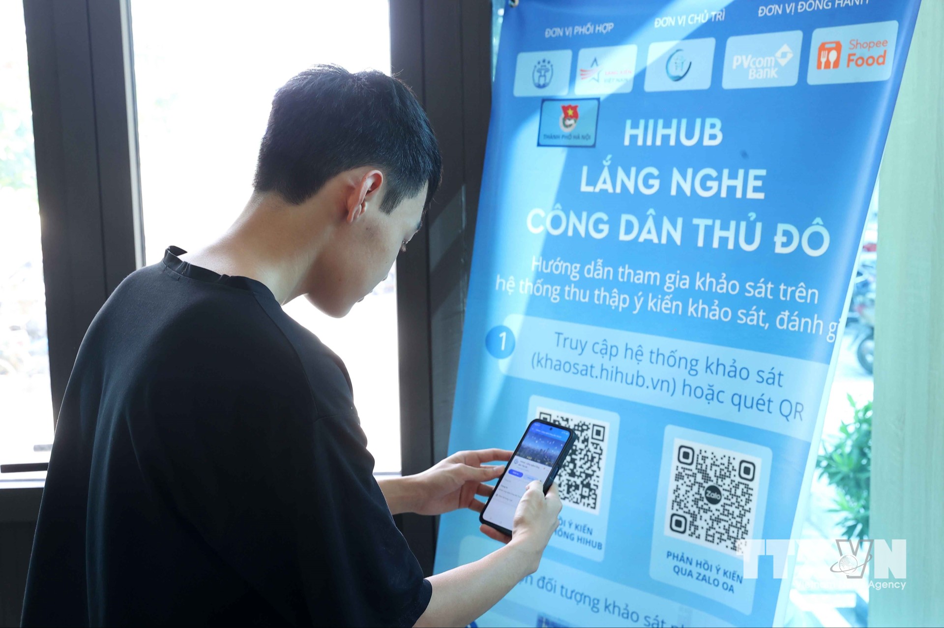 Người dân quét mã QR truy cập trên hệ thống thu thập ý kiến khảo sát, đánh giá tại điểm phục vụ hành chính công xã Phúc Thịnh. (Ảnh: Văn Điệp/TTXVN)